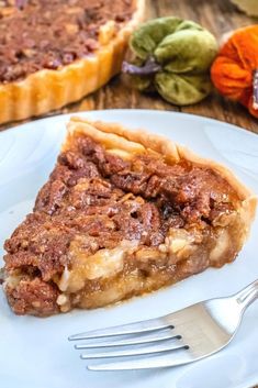 a slice of pecan pie on a white plate with a fork next to it