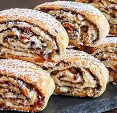 several pastries stacked on top of each other with powdered sugar and raisins