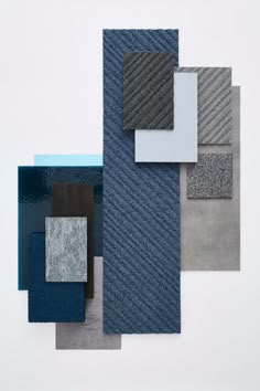 an array of different colors and patterns on a white surface, including blue, gray, black, and grey