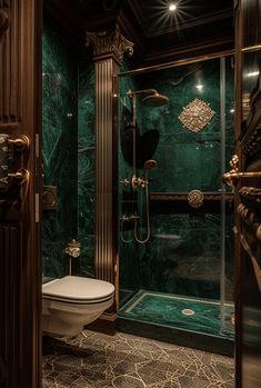 a fancy bathroom with green marble walls and flooring, including a walk in shower