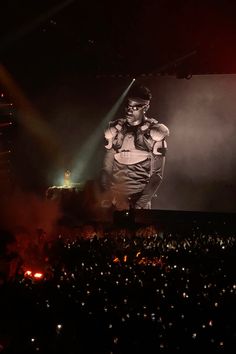 a man standing on top of a stage in front of a crowd