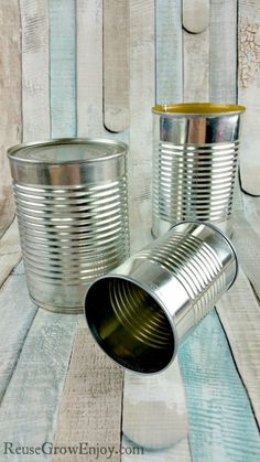 two tin cans sitting on top of a wooden table