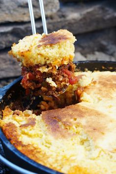 a close up of a piece of food in a skillet with a spatula