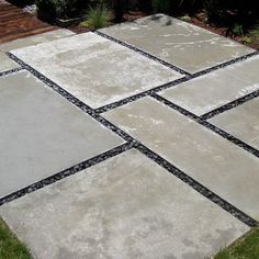 an outdoor patio with stone tiles and grass