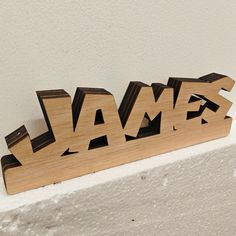 the word james spelled with wooden letters on top of a white wall in an unfinished room