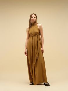 Imagine a dress that effortlessly blends comfort with a captivating wow factor. This statement piece features a flowy silhouette and eye-catching detailing. Crafted in soft, natural, breathable fabric, it can be worn in two ways, adding to its versatility. Available in a variety of colours and print. PRODUCT DETAILS Halter neck design Long maxi dress Versatile wear: can be worn in two ways, either loose or tight around the lower bust Loose fit or wraparound style Bump friendly Low back (elasticated at the back for seamless comfort) Long bow detail at the back for added elegance and style Designed in Australia Soft and light natural fabric Made with ecovero CONSIDERED NATURAL FABRIC Made with Lenzing EcoVero fabric, an eco-friendly sustainable material. EcoVero fabric has a very soft hand f Flowy Silk Pre-draped Maxi Dress, Spring Pre-draped Flowy Dress, Chic Draped Maxi Dress For Fall, Elegant Flowy Maxi Sleeveless Dress, Elegant Flowy Sleeveless Maxi Dress, Elegant Halter Neck Viscose Dress, Flowy Draped Spring Dresses, Sleeveless Flowy Beige Dress, Sleeveless Beige Dress With Flowy Skirt