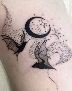 a black and white image of two bats flying in the sky at night with stars on their wings