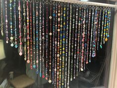 a bunch of beads hanging from the side of a window