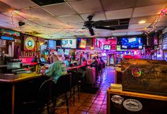 people are sitting at the bar and watching tvs