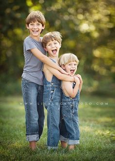 two young boys hugging each other while standing in the grass with their arms around each other