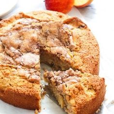 a close up of a cake on a table with an apple in the back ground