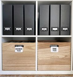 three wooden boxes with labels on them sitting in front of a bookcase filled with files