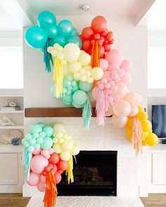 balloons are hanging from the ceiling in front of a fireplace