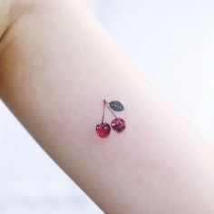 two cherries on the back of a woman's arm