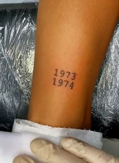 a person with a small tattoo on their arm and the word 1911 written in black ink