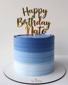 a blue and white cake with a gold happy birthday cake topper that says, happy birthday mate