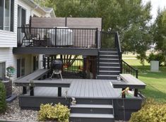 a deck with steps leading up to the second floor and an outdoor grill on the other side