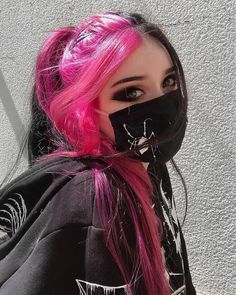 a woman with pink hair wearing a black face mask