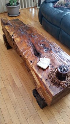 a wooden table sitting on top of a hard wood floor next to a blue couch