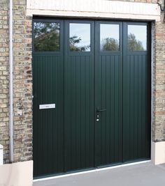 a green garage door with two windows