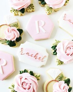 decorated cookies with pink frosting and roses on them are arranged in the shape of letters