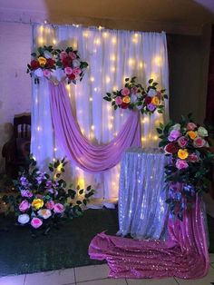 a decorated stage with flowers and lights in the background