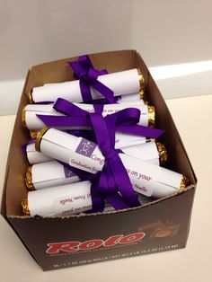 a box filled with white chocolates wrapped in purple ribbon