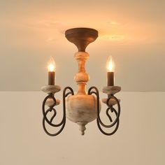 a wooden chandelier with two candles hanging from it's center and one light on the other side