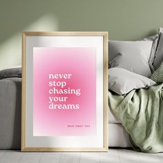 a pink poster with the words never stop chasing your dreams in front of a couch