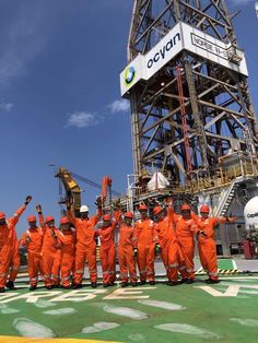 a group of men in orange uniforms standing next to each other