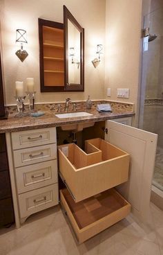 a bathroom with two sinks and drawers in the middle of the counter top, next to a walk in shower