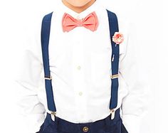 a young boy wearing suspenders and a bow tie