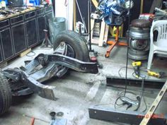 the front end of a car being worked on in a garage with tools and equipment