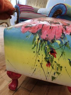 the foot stool is painted with flowers on it