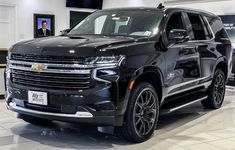 a black suv is on display in a showroom