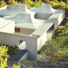 an aerial view of a concrete house surrounded by trees