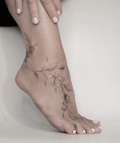 a woman's foot with a flower tattoo on her left side and the bottom part of her leg