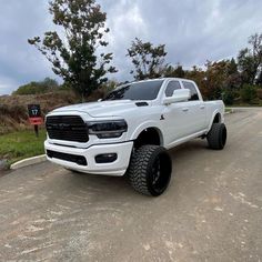 a white ram truck is parked on the street