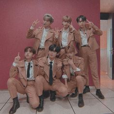 a group of young men in suits and ties posing for a photo with their fingers up