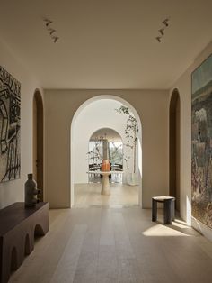 an archway leads to a living room with art on the walls and artwork on the floor