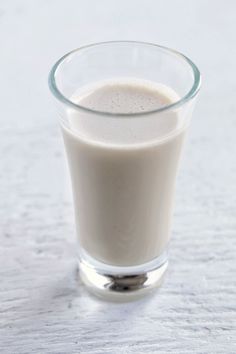 a glass filled with milk sitting on top of a table