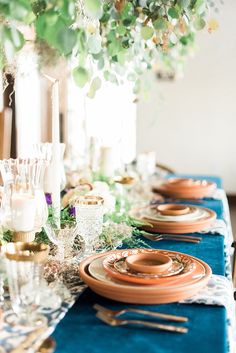 a long table with plates and candles on it