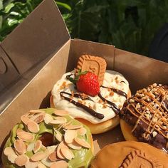 a box filled with assorted donuts covered in toppings