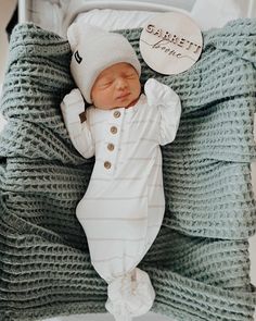 a baby sleeping in a crib wearing a hat