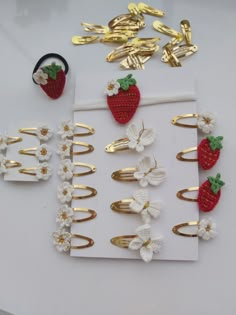 several pieces of crocheted hair clips with strawberries and flowers on them sitting next to each other