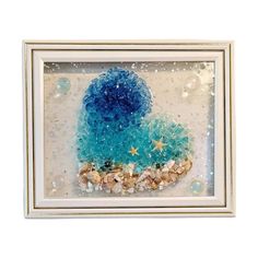 a blue and white framed artwork with starfishs, seashells and bubbles