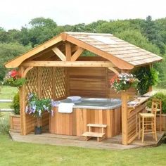 a wooden hot tub sitting on top of a lush green field