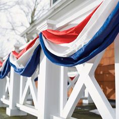 several red, white and blue flags are lined up on the side of a house