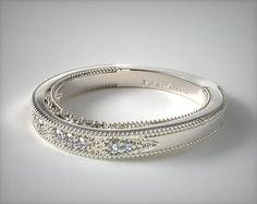 a wedding ring with three rows of diamonds on top of each other, in white gold