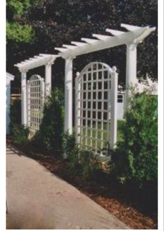 an outdoor garden with white trellis and arbors